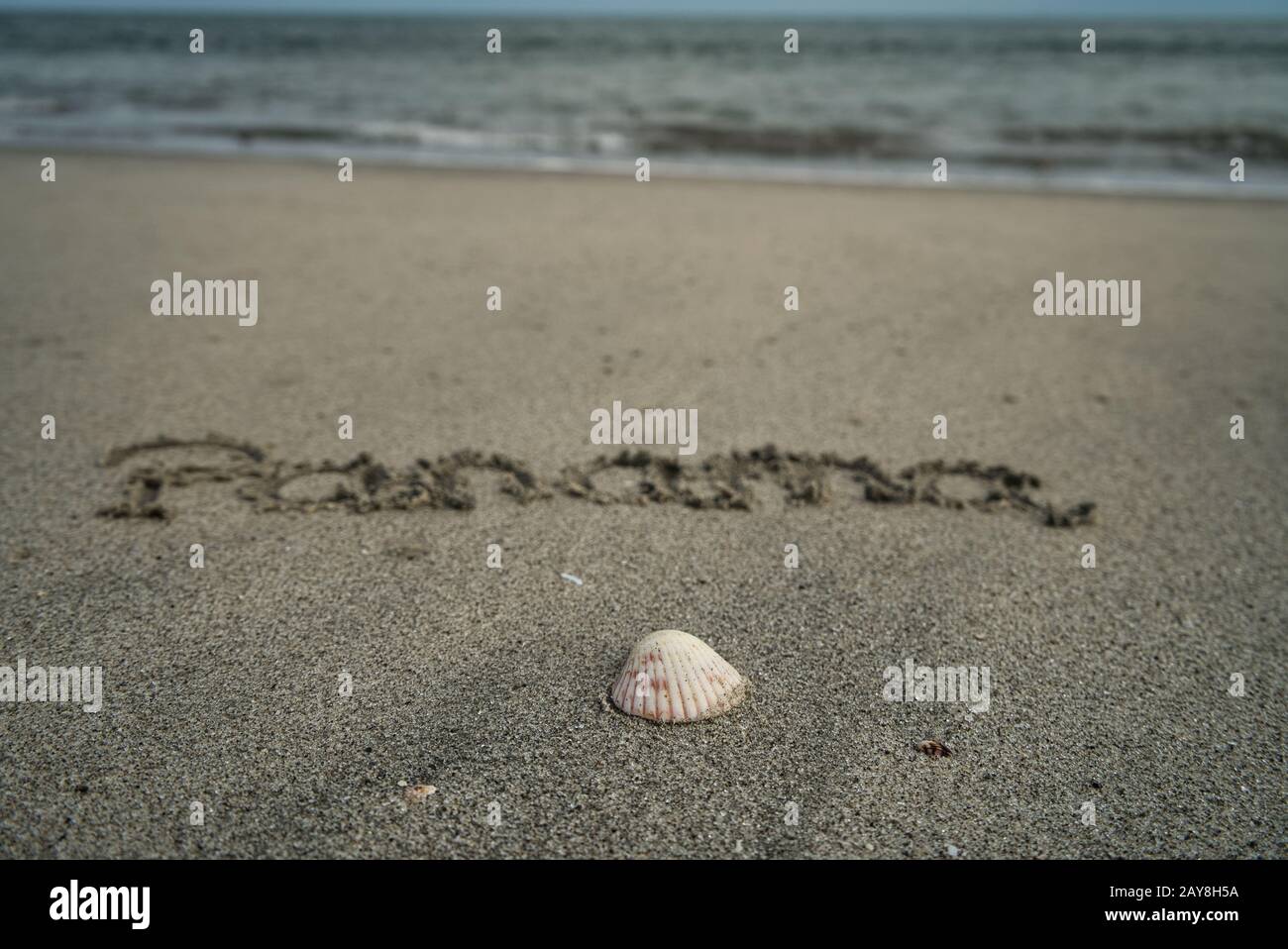 Concentrez-vous sur une coquille à la plage avec l'horizon en arrière-plan et Panama écrit dans le sable Banque D'Images