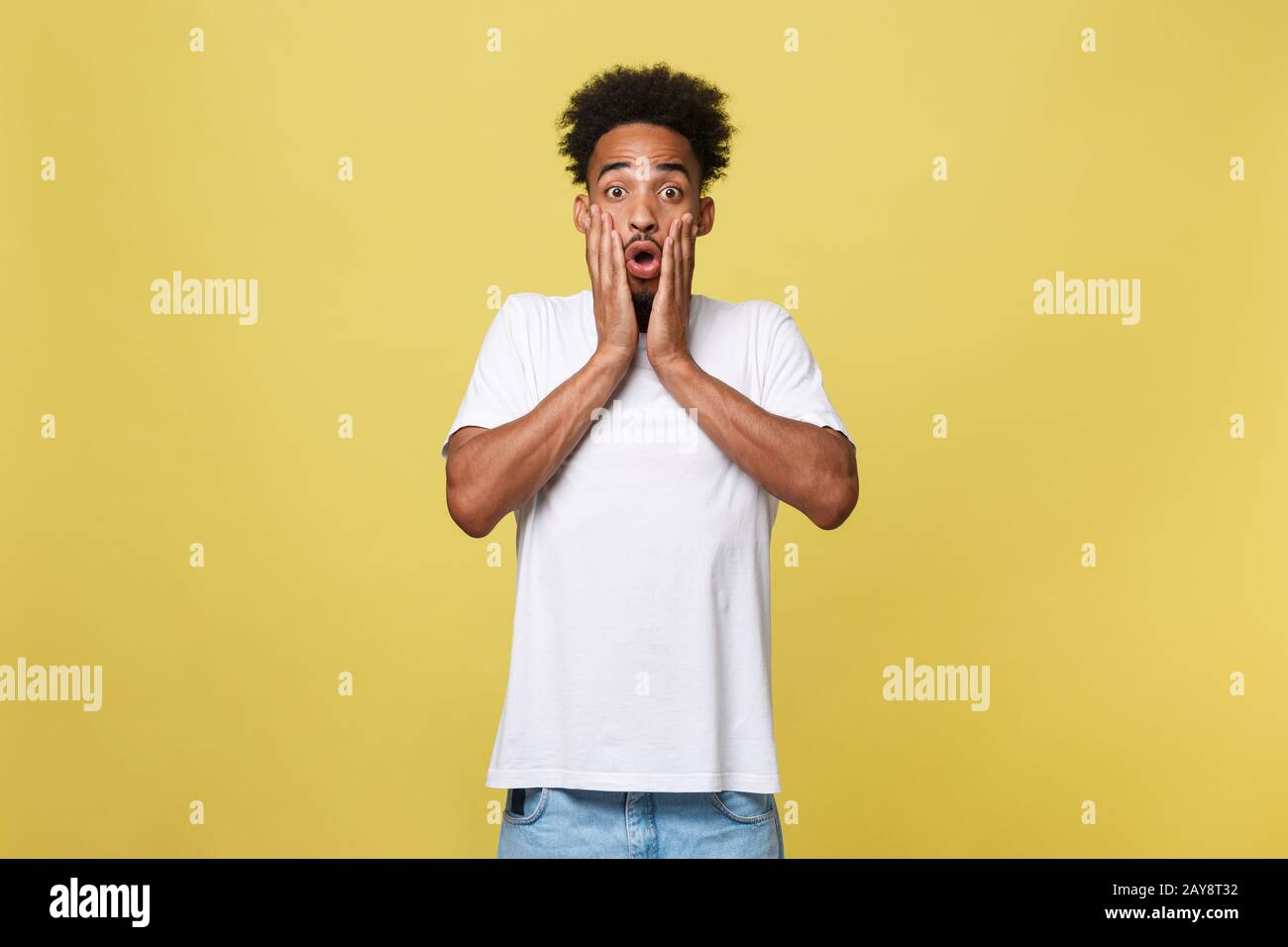 Concept émotionnel et Humain - Portrait de jeune homme africain excité hurlant dans le choc et l'étonnement tenant les mains sur Banque D'Images
