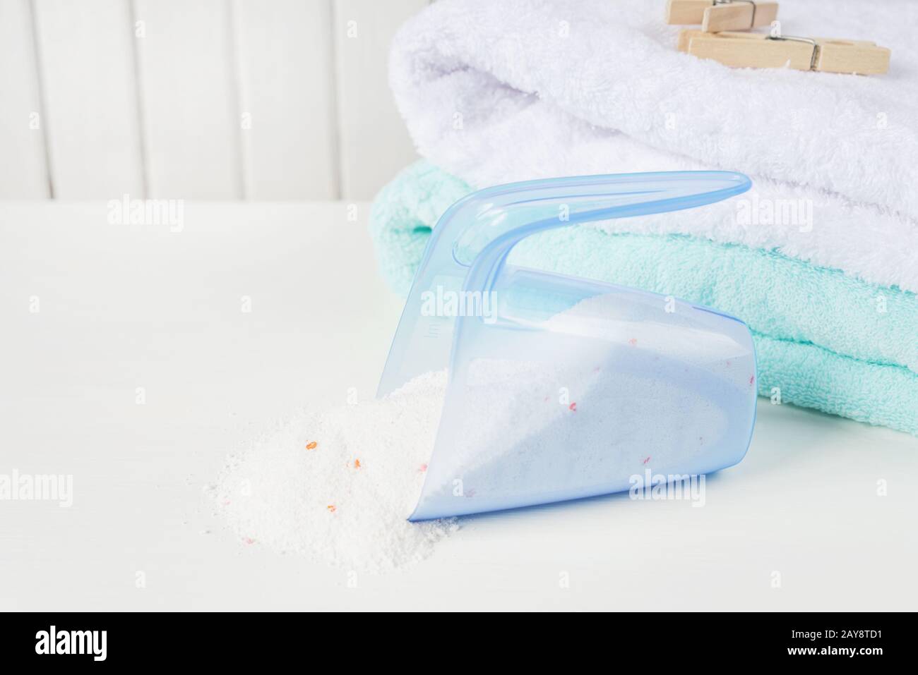 Serviettes de bain, poudre à laver dans la tasse à mesurer et des clous de girolettes en bois Banque D'Images