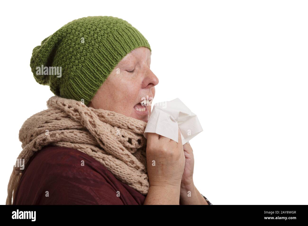 Une femme âgée en hiver atteinte de la maladie doit éternuer et souffler dans un mouchoir isolé sur wh Banque D'Images