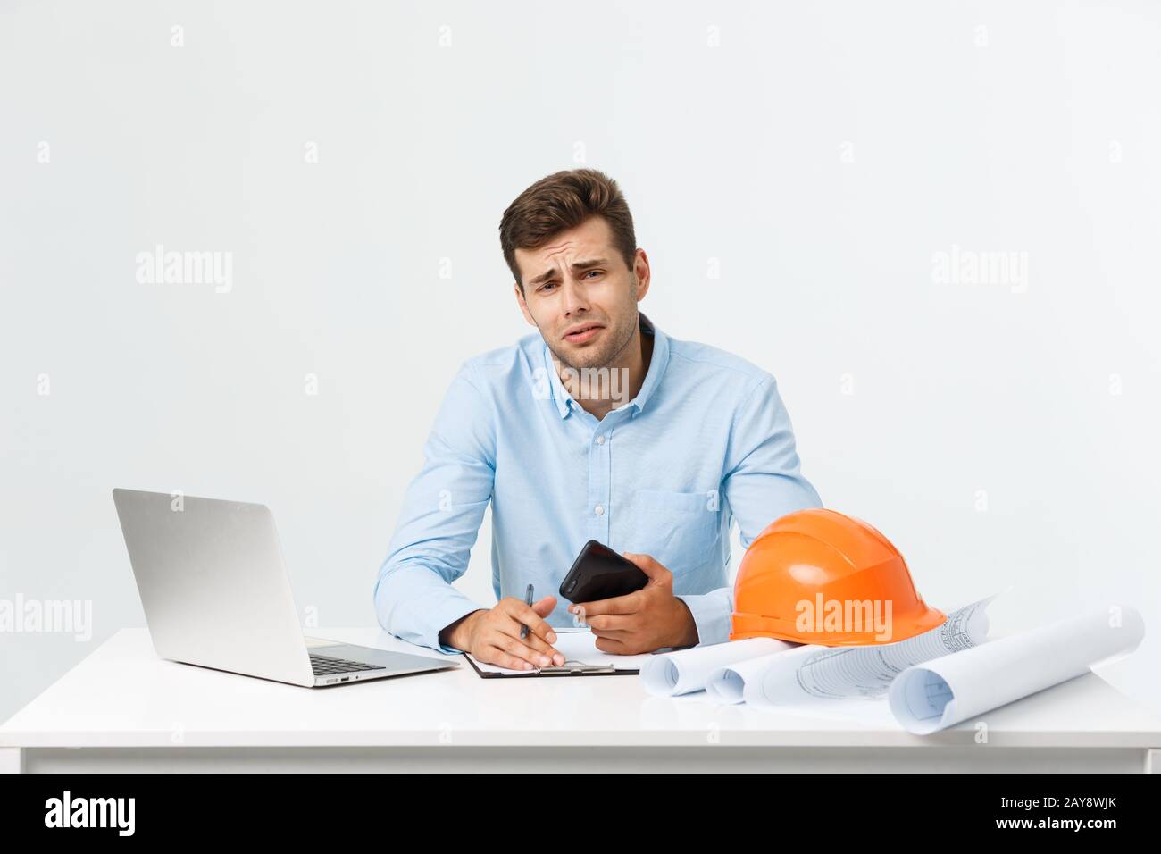 Homme d'affaires sérieux ou ingénieur assis sur le chantier. Un homme d'âge moyen courageux s'assoit avec triste, sérieux et déprimé Banque D'Images