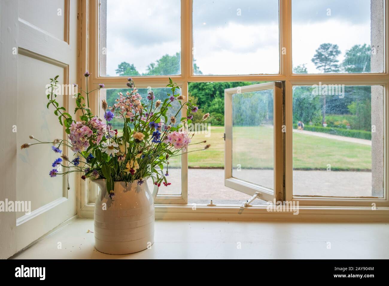 Fleurs et fenêtre donnant sur les jardins d'une maison traditionnelle anglaise majestueux Banque D'Images