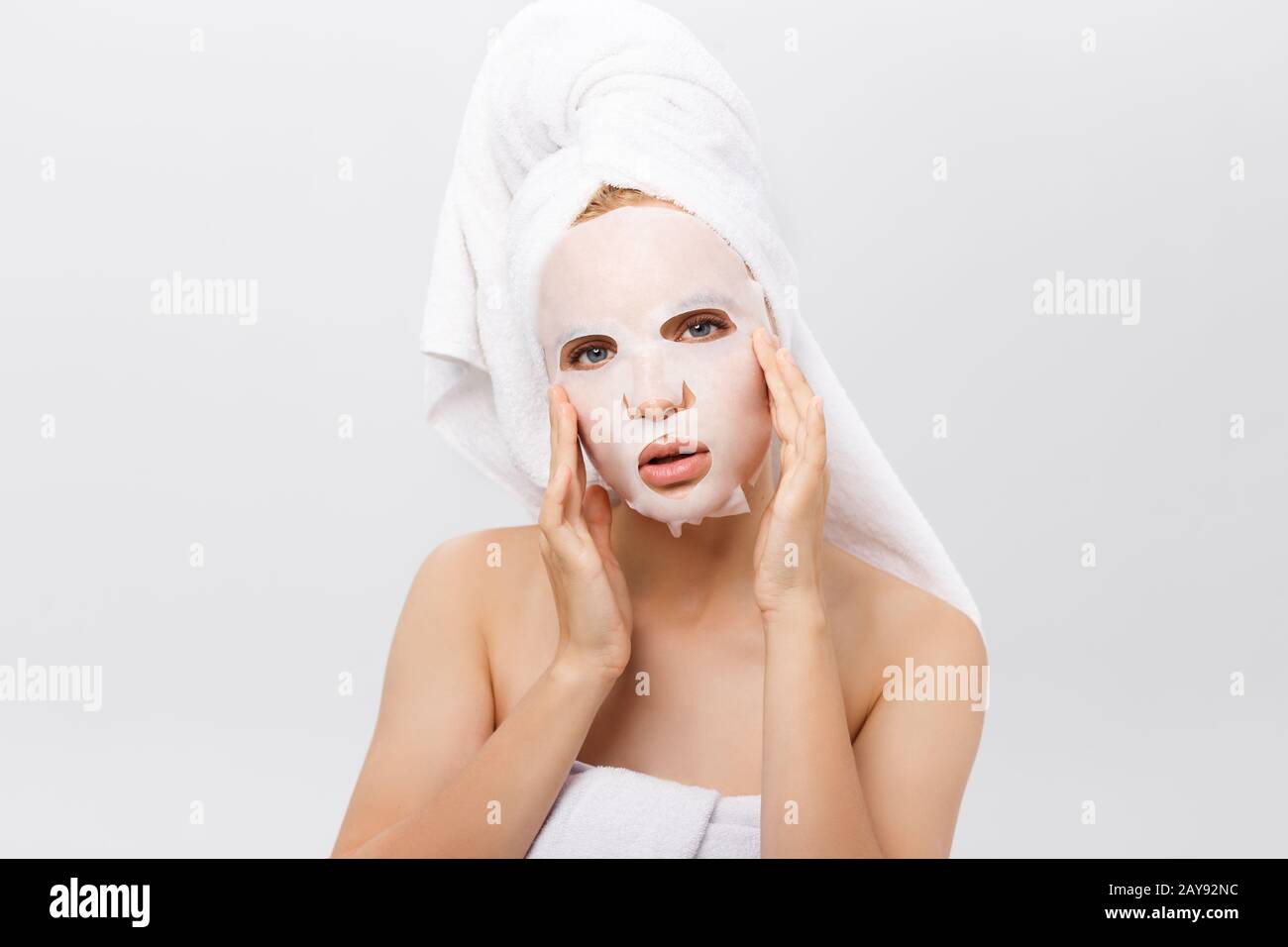 Soins De La Peau - concept beauté Belle Caucasian Woman l'application de la feuille de papier sur son visage masque fond blanc. Banque D'Images