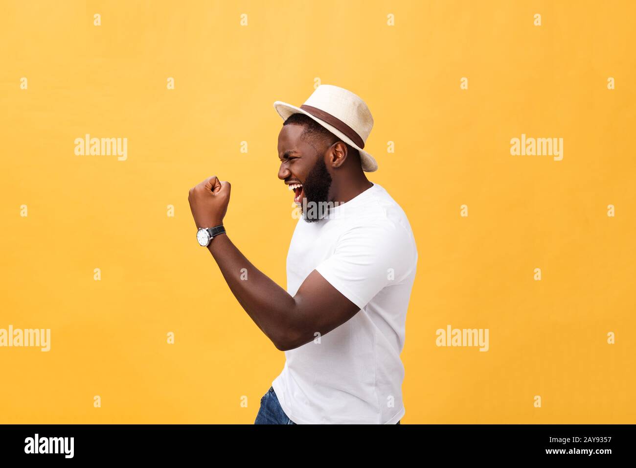 Beau jeune employé afro-américain se sentant excité, gestant activement, gardant les poings serrés, exclamant joyeusement avec Banque D'Images