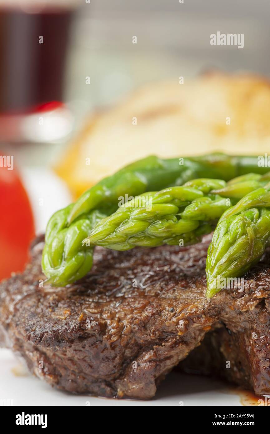 Bifteck de boeuf et asperges vertes sur une plaque Banque D'Images
