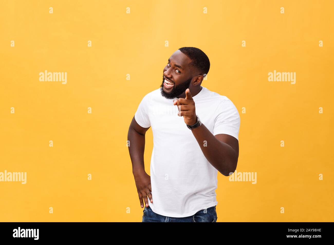 Drôle jeune client africain souriant heureux et pointant ses index doigts à l'appareil photo comme si vous le choix et l'invitation à grand sal Banque D'Images