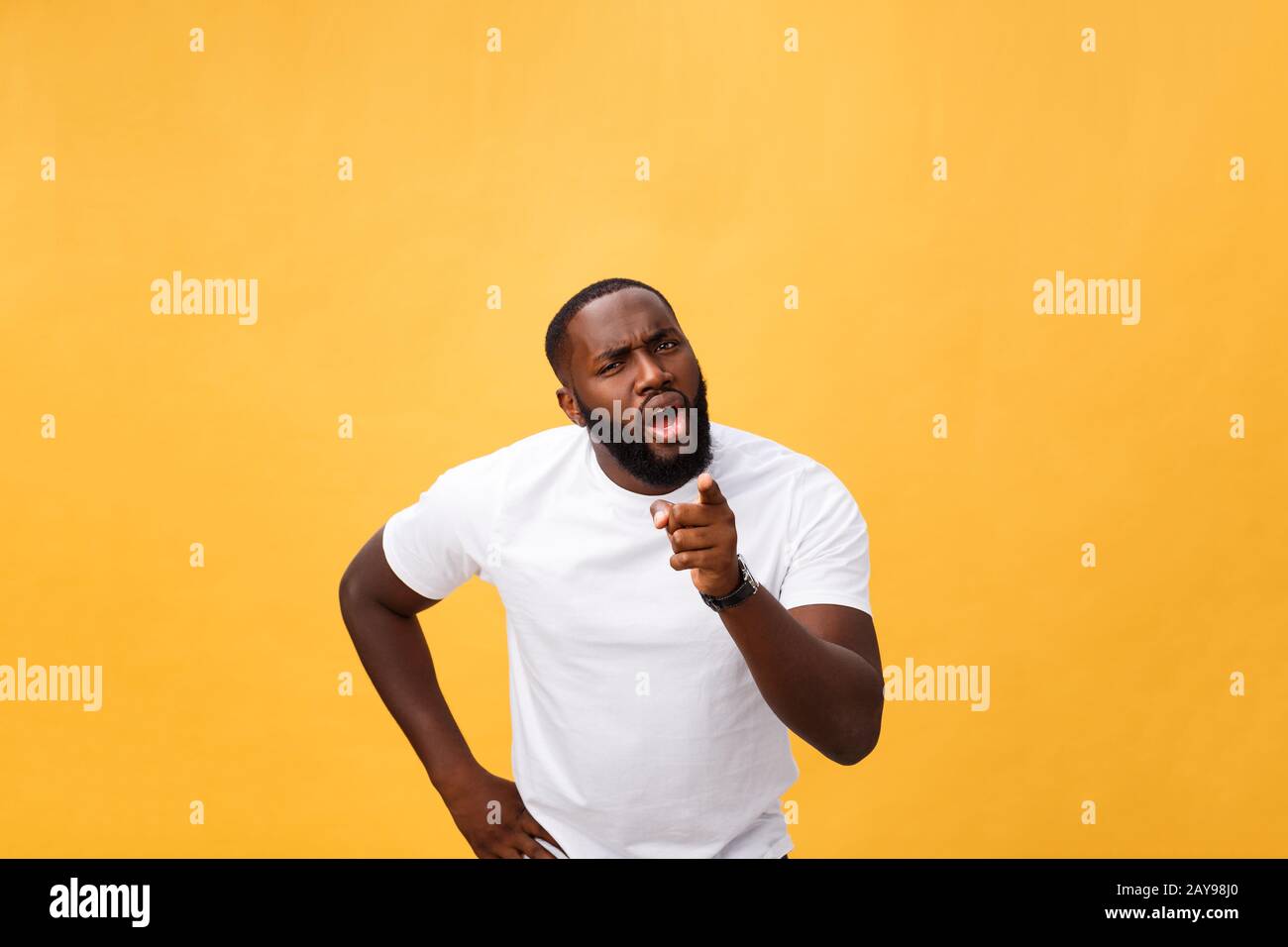 Drôle jeune client africain souriant heureux et pointant ses index doigts à l'appareil photo comme si vous le choix et l'invitation à grand sal Banque D'Images