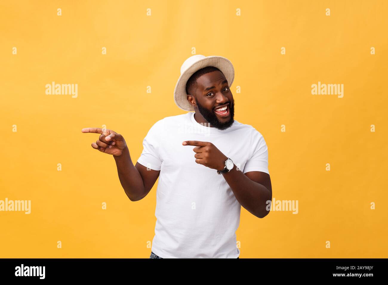 Drôle jeune client africain souriant heureux et pointant ses index doigts à l'appareil photo comme si vous le choix et l'invitation à grand sal Banque D'Images