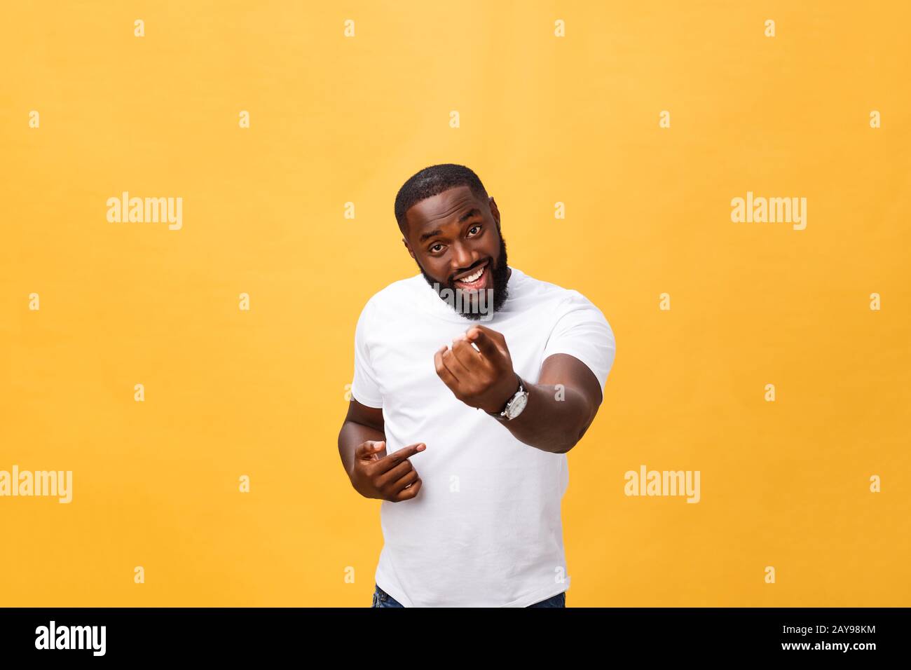 Drôle jeune client africain souriant heureux et pointant ses index doigts à l'appareil photo comme si vous le choix et l'invitation à grand sal Banque D'Images