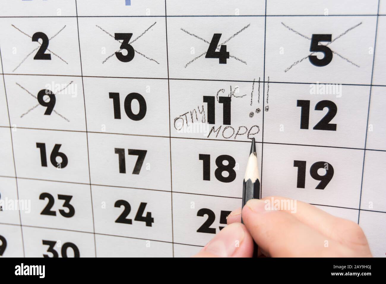 La main avec un crayon écrit les mots vacances et mer sur un calendrier mural Banque D'Images