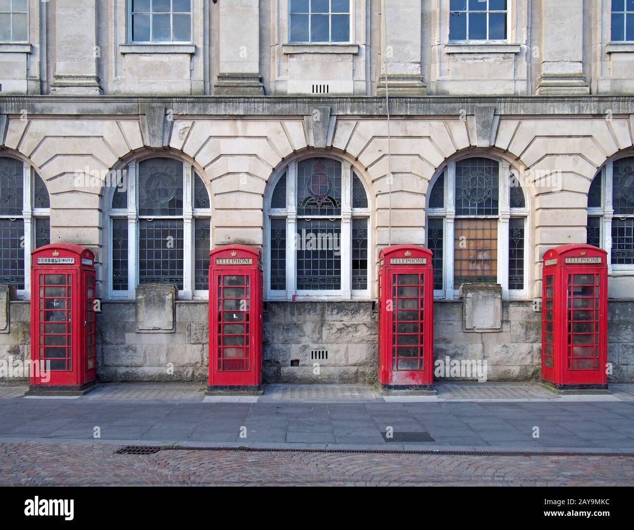 une ligne de quatre boîtes téléphoniques rouges britanniques traditionnelles à l'extérieur d'un ancien bâtiment de poste à blackpool Banque D'Images