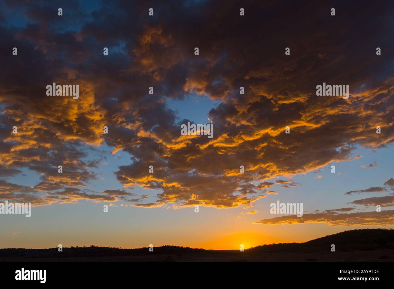 Coucher de soleil sur les collines de la Réserve de jeux d'Ongava, au sud du parc national d'Etosha, dans le nord-ouest de la Namibie. Banque D'Images
