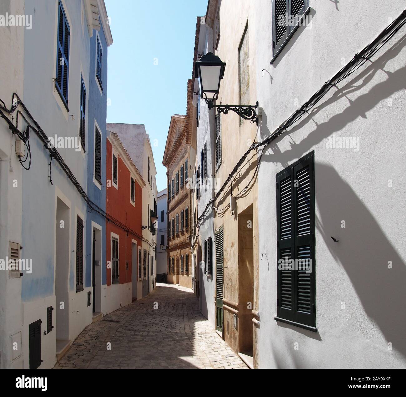 Une rue de ville vide lumineuse et ensoleillée de maisons anciennes pittoresques à Ciutadella menorca Banque D'Images