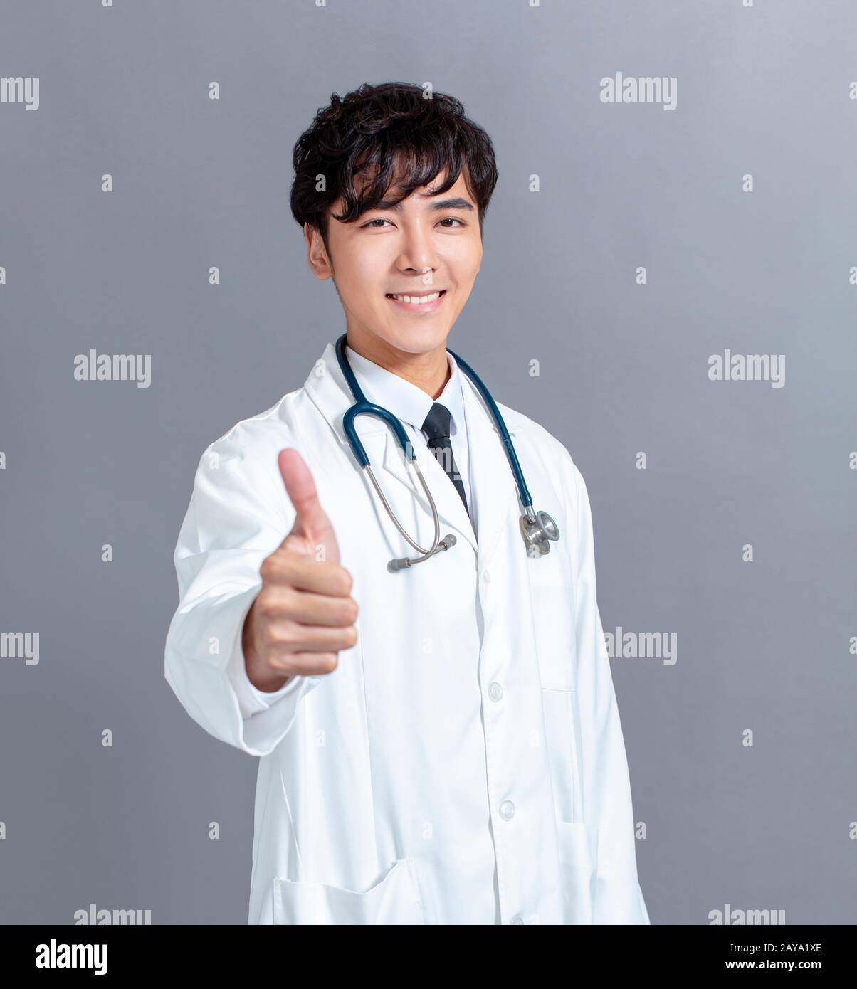un médecin asiatique amical vous donne des pouces Banque D'Images