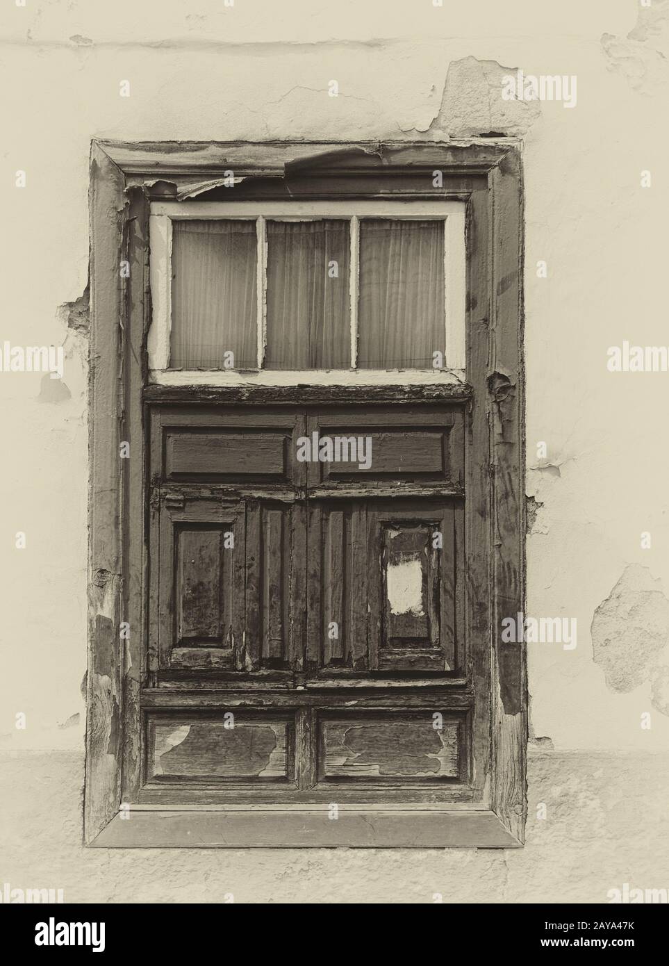une image sépia d'une vieille fenêtre à volets espagnols dans une maison traditionnelle avec des murs en plâtre délavés Banque D'Images