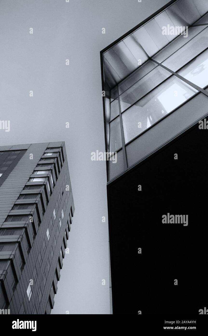 vue abstraite des immeubles de bureaux la nuit en regardant vers le haut avec des lumières dans les fenêtres Banque D'Images