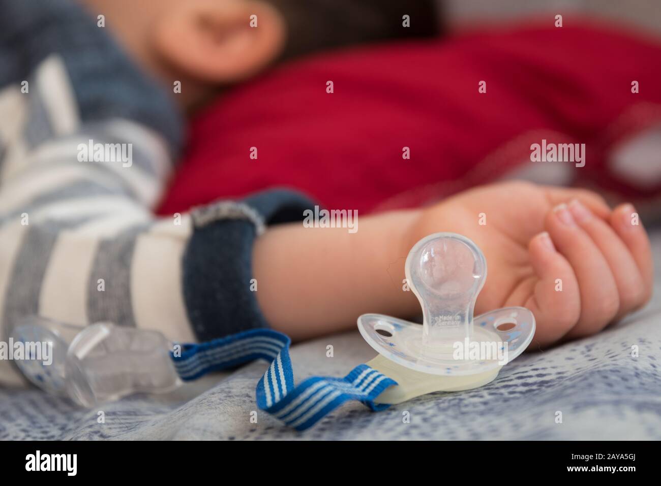 bébé endormi avec sucette à côté de la main - gros plan Banque D'Images