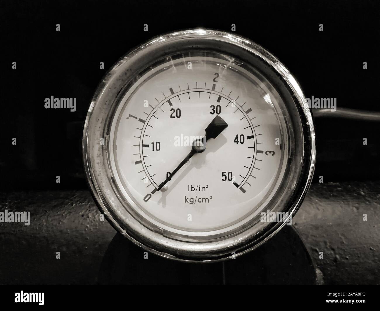 image monochrome d'une jauge ronde brillante de pressuremillésime avec des nombres marqués en psi et métrique sur le cadran du compteur sur ma industriel Banque D'Images