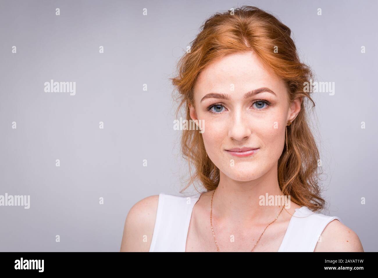 Gros plan portrait jeune, belle femme d'affaires, étudiant avec lred, cheveux frisés et freckles sur le visage sur fond gris dans les s Banque D'Images