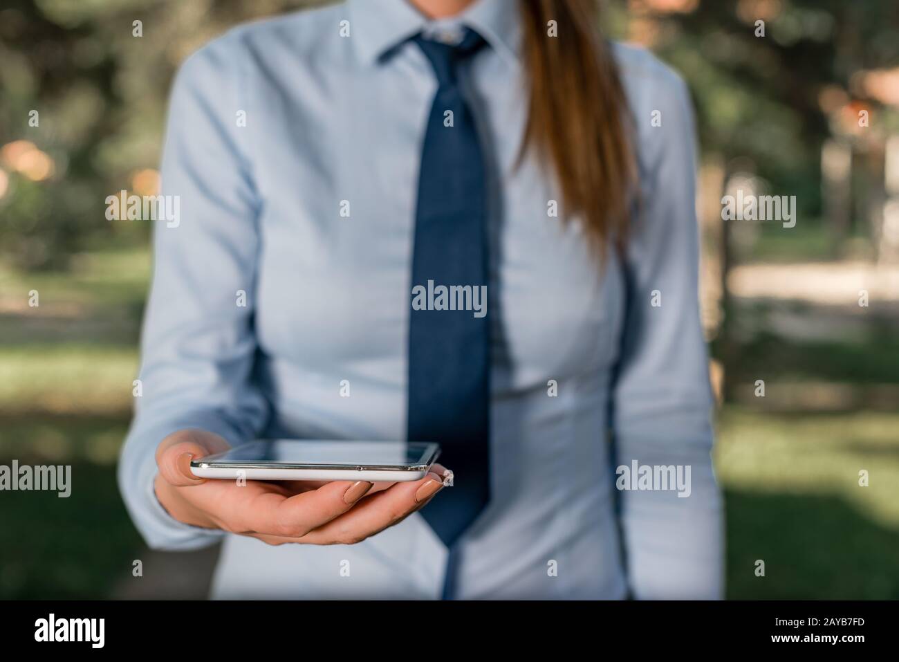 Femme d'affaires en chemise avec une cravate tenant le téléphone portable  haut de tour dans la main. Concept de communication avec téléphone mobile  et bus Photo Stock - Alamy