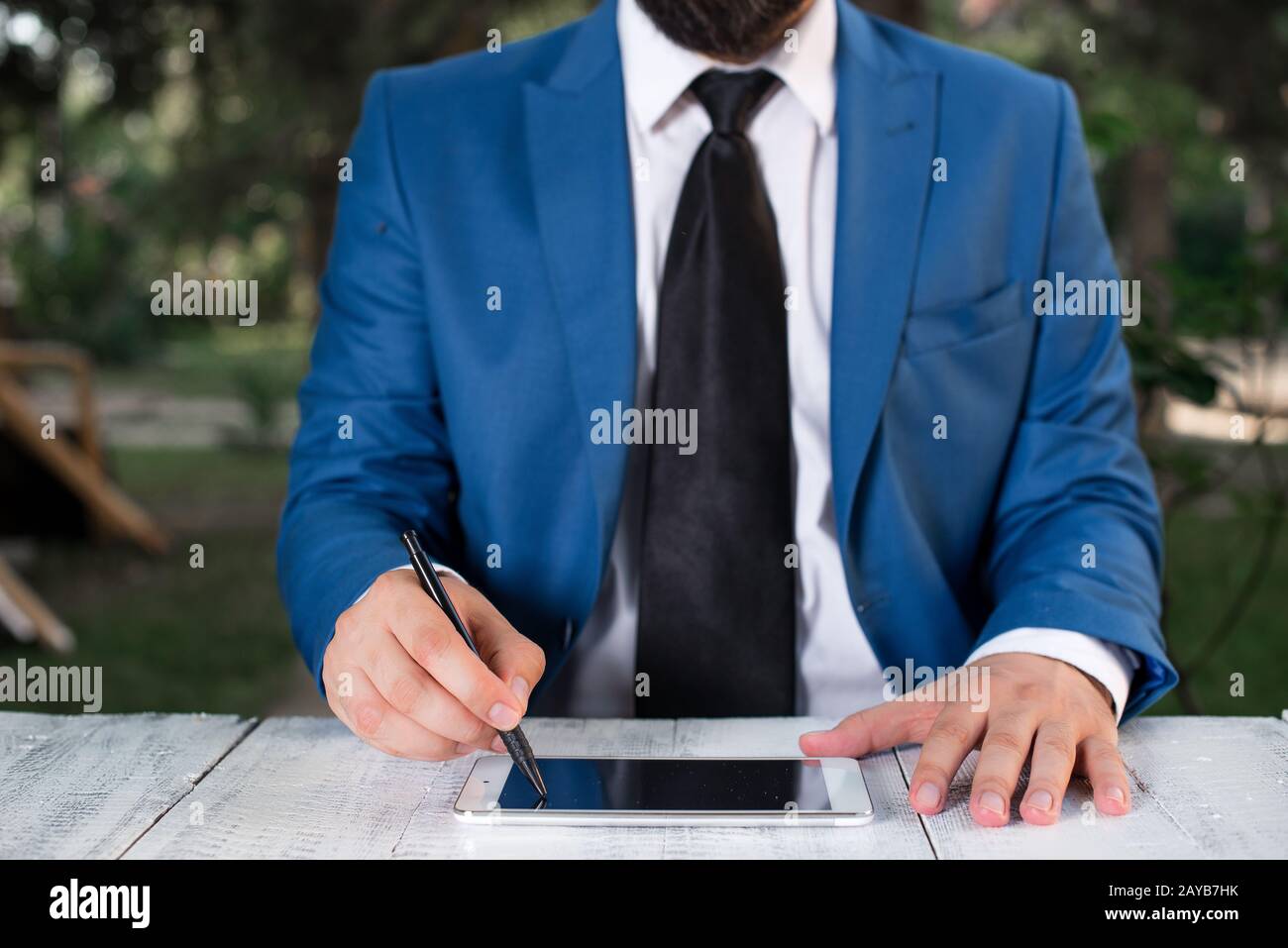 Homme d'affaires tient le stylo et pointe dans l'espace de copie. Homme avec le dessus de tour et le stylo dans la main. Concept d'affaires avec homme dans la suite W Banque D'Images