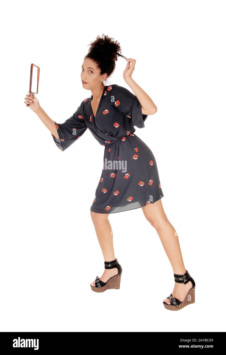 Belle femme dans une robe noire fixant ses cheveux Banque D'Images