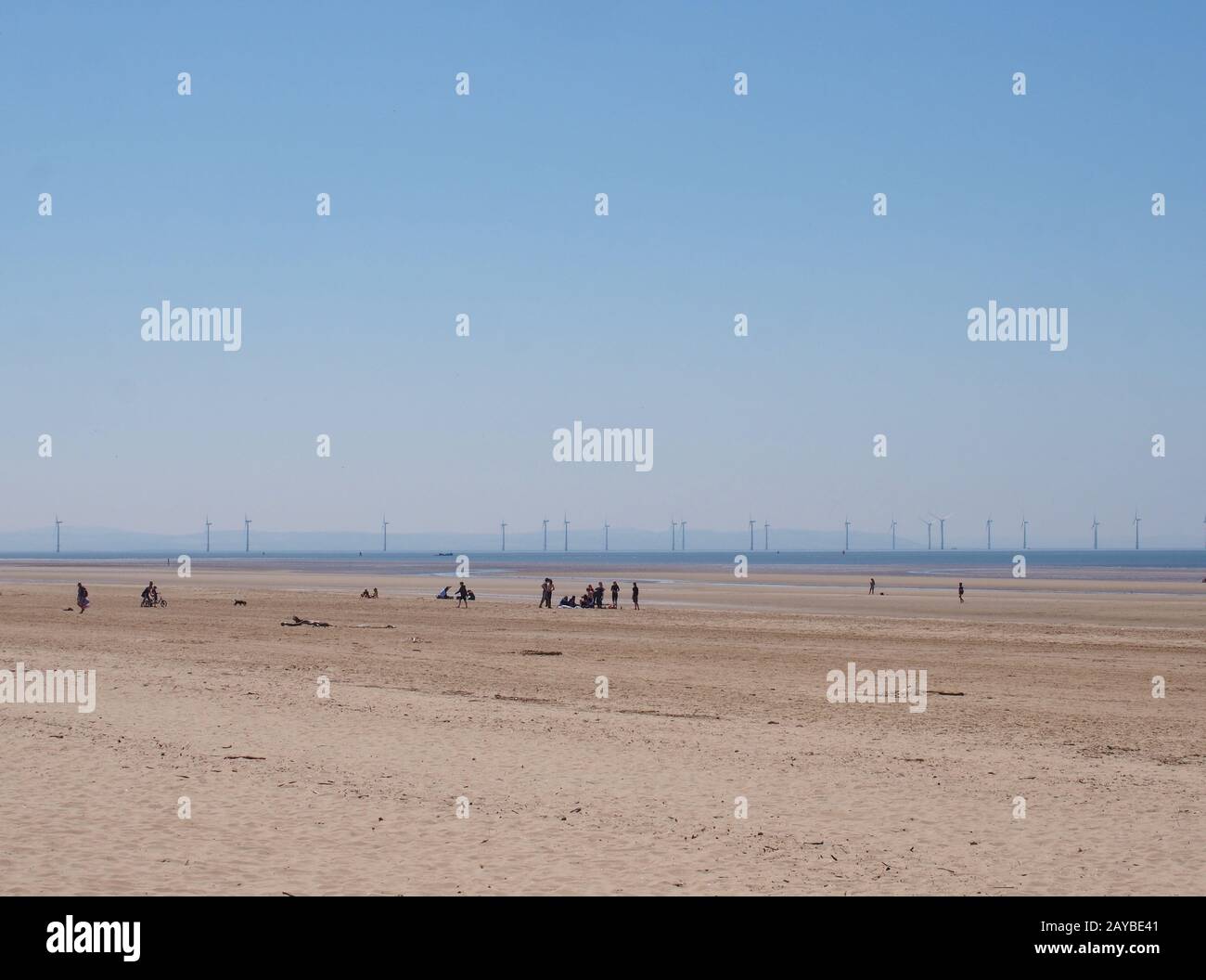 vue sur une grande plage d'été couverte de sable plat à formby merseyside avec des personnes non reconnaissables à la distance moyenne et le vent Banque D'Images