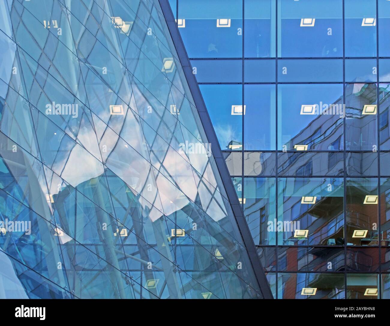 le ciel bleu et les bâtiments se reflètent et se reflètent dans un grand bâtiment de bureau commercial futuriste moderne Banque D'Images