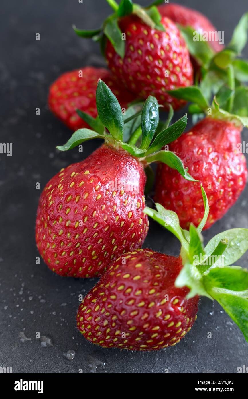 Baies fraises mûres sur fond noir. Banque D'Images