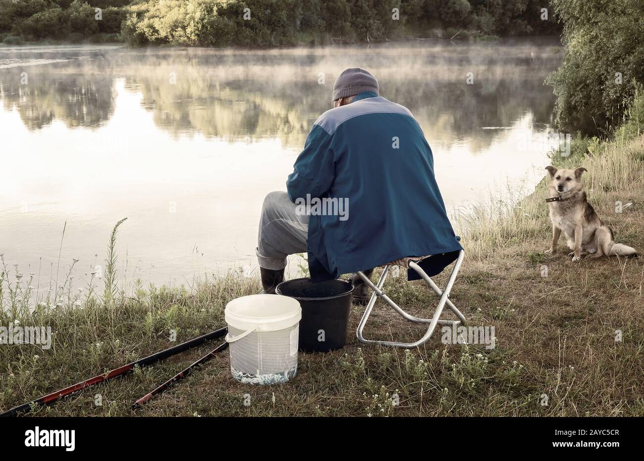 Un homme pêche sur la rive d'un lac magnifique. Banque D'Images