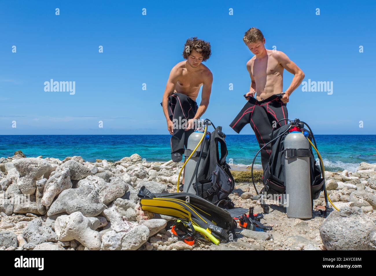 Deux plongeurs changent de vêtements à la plage Banque D'Images