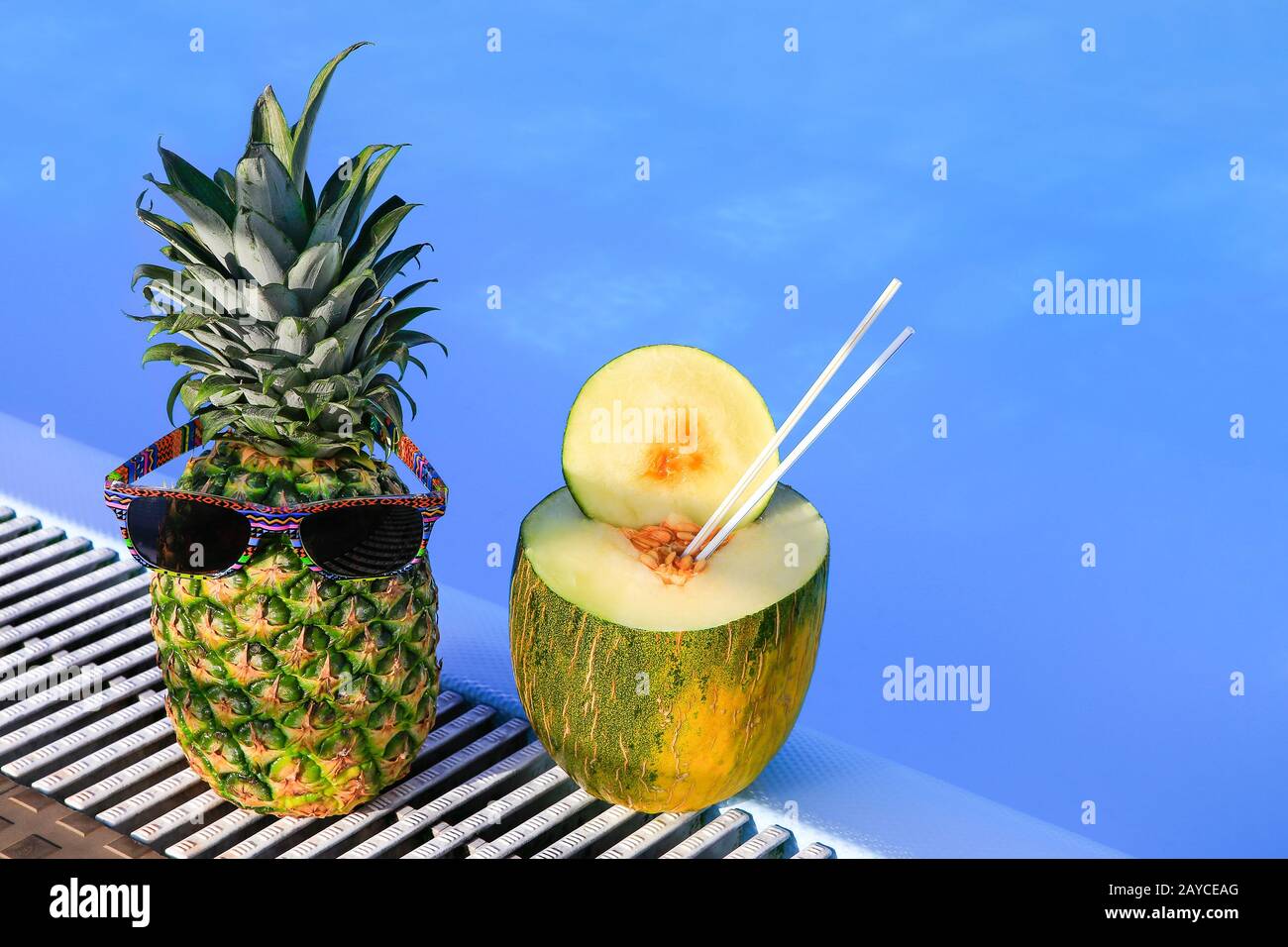 Ananas portant des lunettes de soleil et du melon à la piscine Banque D'Images