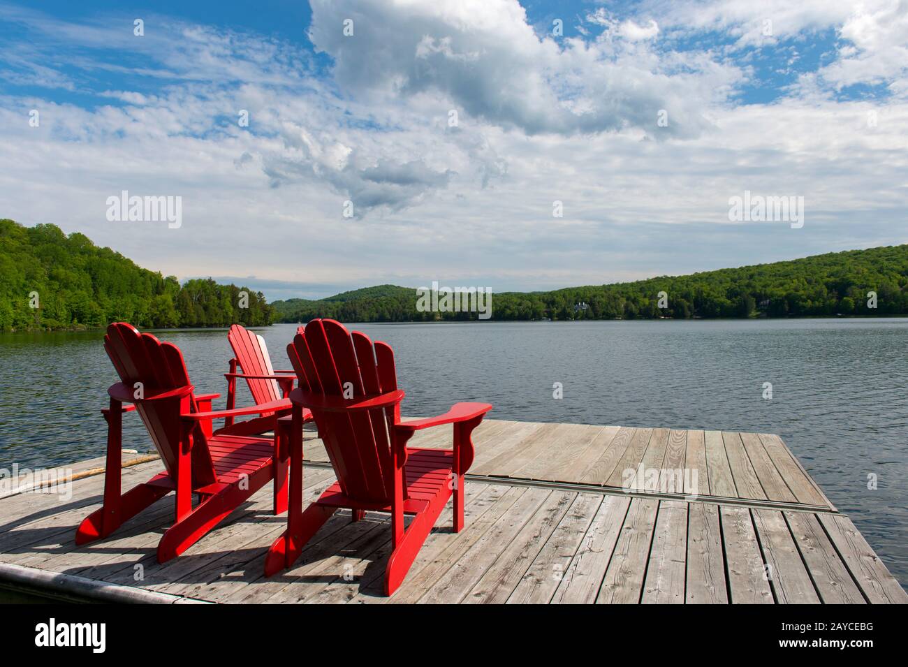 Vue sur un quai avec des chaises rouges Adirondack au Lac Mercier du petit train du Nord Bike Path près du vieux village de Mont-Tremblant dans les Laurentides Banque D'Images