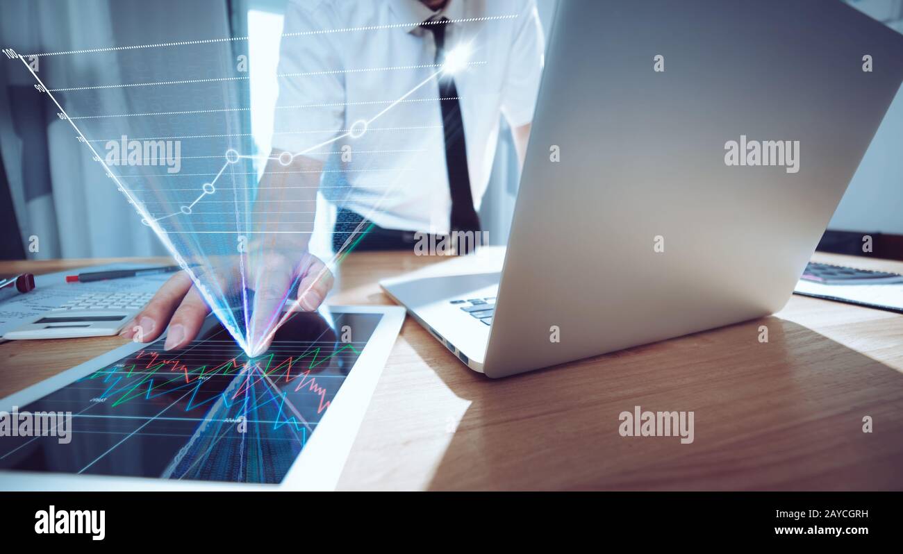 Homme d'affaires utilisant un ordinateur portable et une tablette numérique pour analyser le rapport de vente Banque D'Images