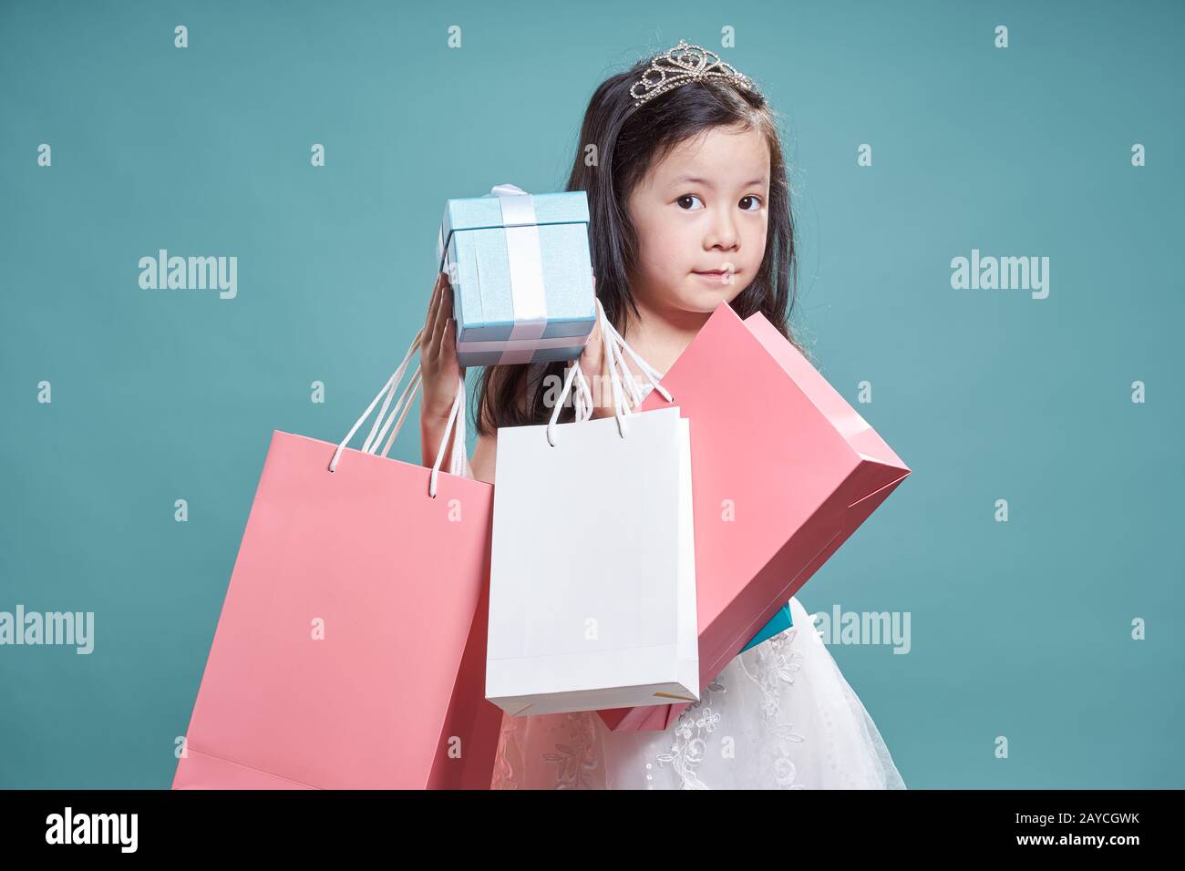 Portrait de petite fille belle asiatique holding present fort et panier vintage sur fond bleu . Banque D'Images