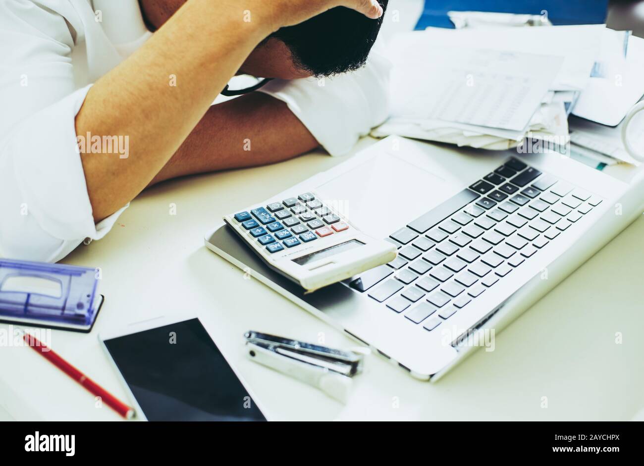 L'homme à l'aide de la calculatrice et de comptage en stress problème avec les dépenses. Banque D'Images