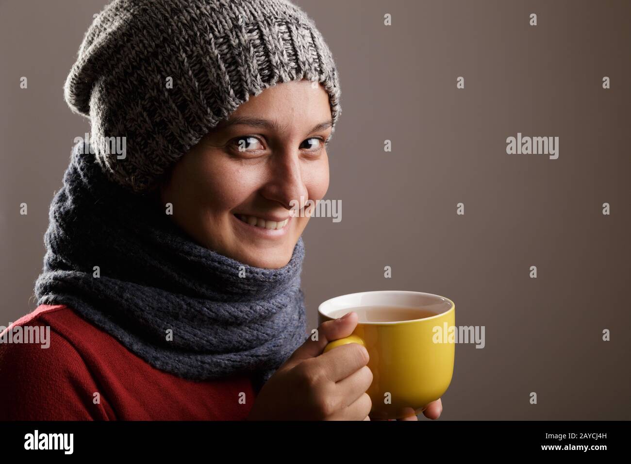 Jeune femme portant une écharpe de laine et un capuchon de boire du thé chaud. L'automne et l'hiver et la maladie concept. Banque D'Images