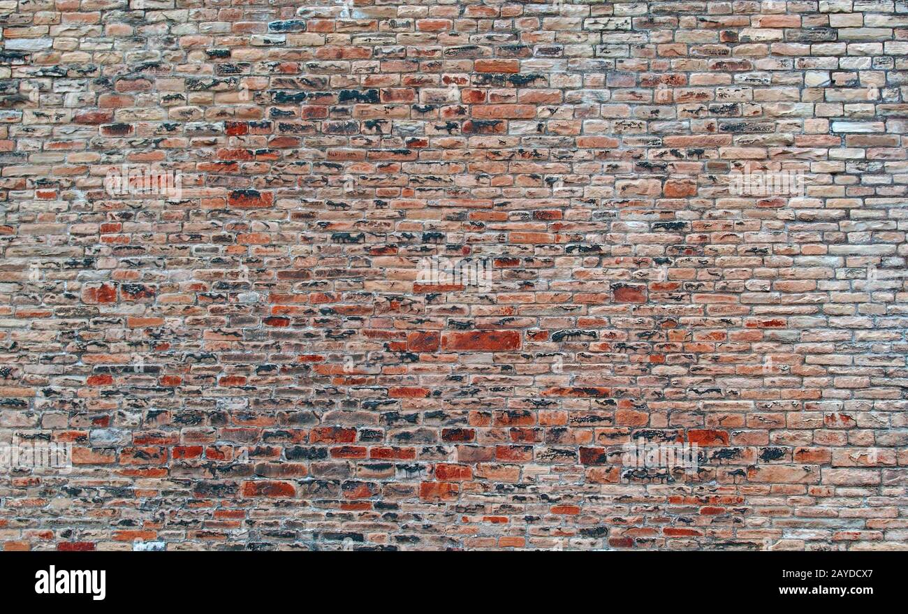mur en pierre rouge extérieur avec de nombreuses briques rugueuses inégales et surface texturée Banque D'Images