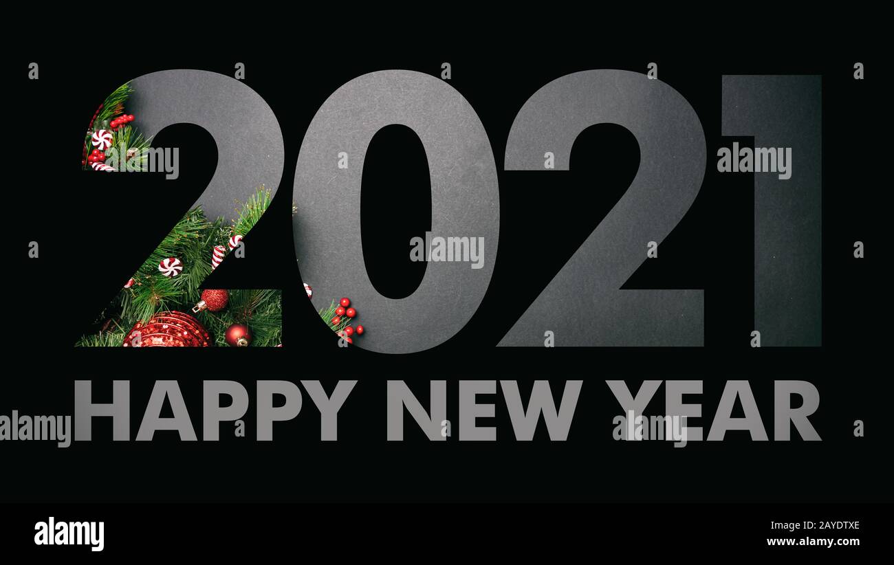 2021 la veille du nouvel an. Papier noir découpé numéro 2021 couche contre les ornements de Noël sur fond gris. Bonne année, texte, modèle de carte de vœux Banque D'Images