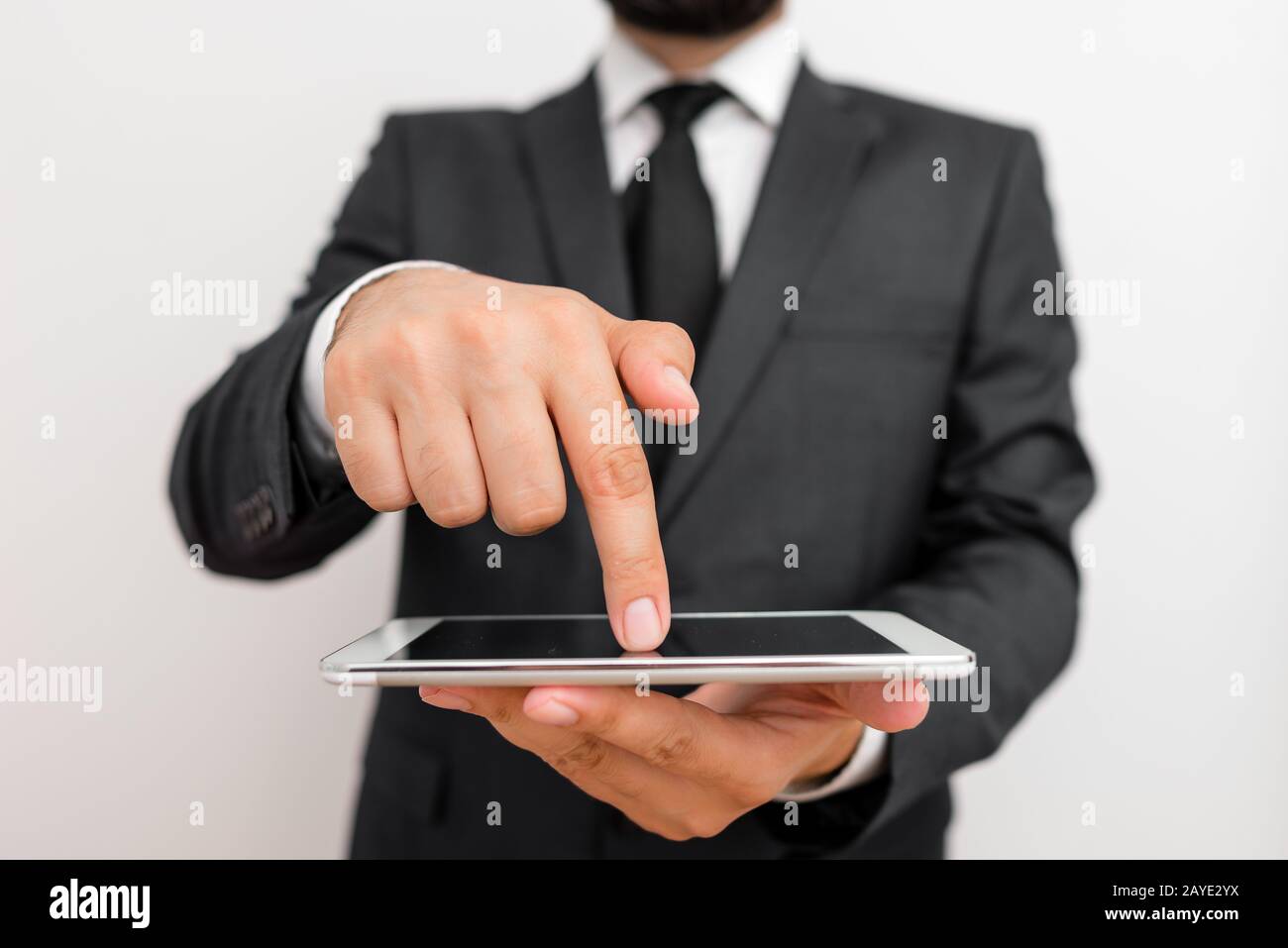 Homme vêtements de travail habillés vêtements de travail formels présentant la présentation d'un smartphone de haute technologie. Homme vêtu d'un costume de travail pl Banque D'Images