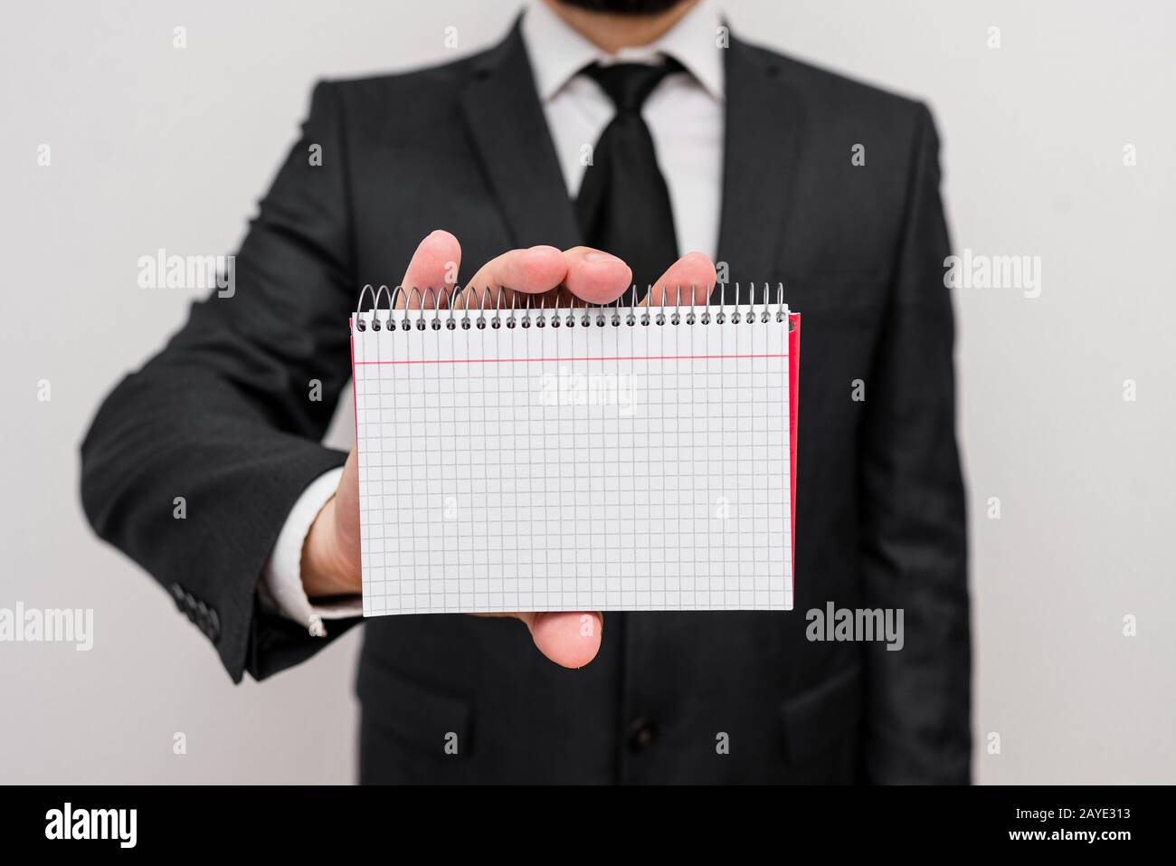 Homme debout et porter des vêtements de travail formels tenir des feuilles de maths papier. Homme vêtu d'une robe de costume de travail et d'un bureau à nouer Banque D'Images