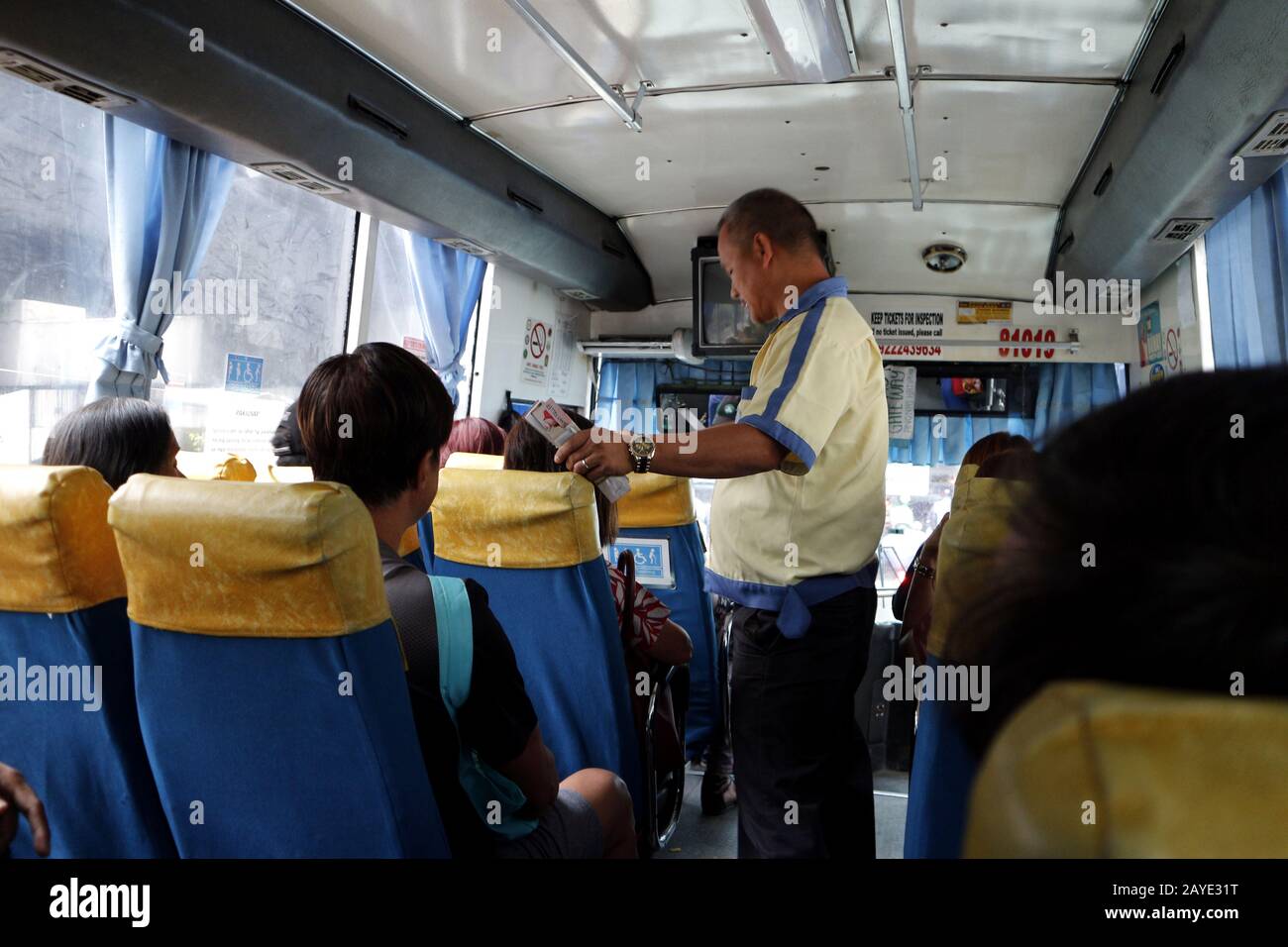 Mandaluyong City, Philippines - 13 février 2020: Le conducteur de bus donne un billet de bus à un passager après avoir payé le tarif. Banque D'Images
