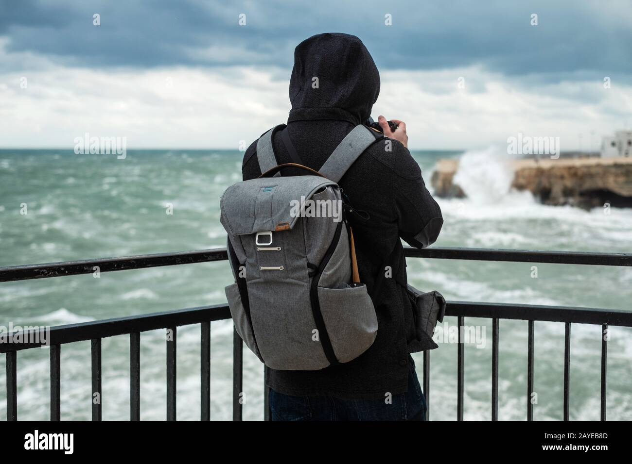 Photographe prenant photo d'une mer de tempête à Polignano a Mare, Italie. Banque D'Images