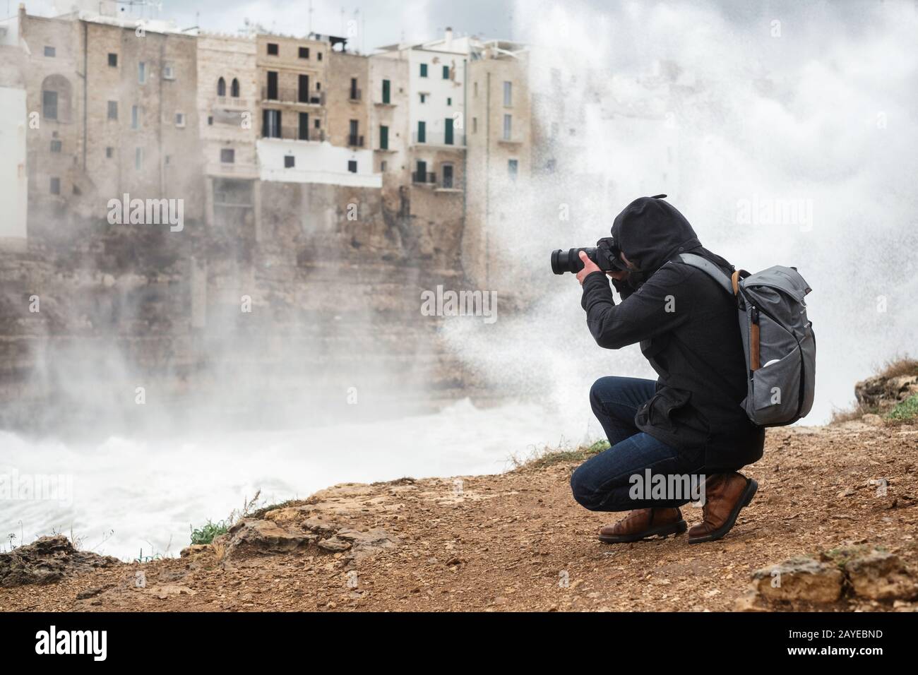 Photographe prenant photo d'une mer de tempête à Polignano a Mare, Italie. Banque D'Images