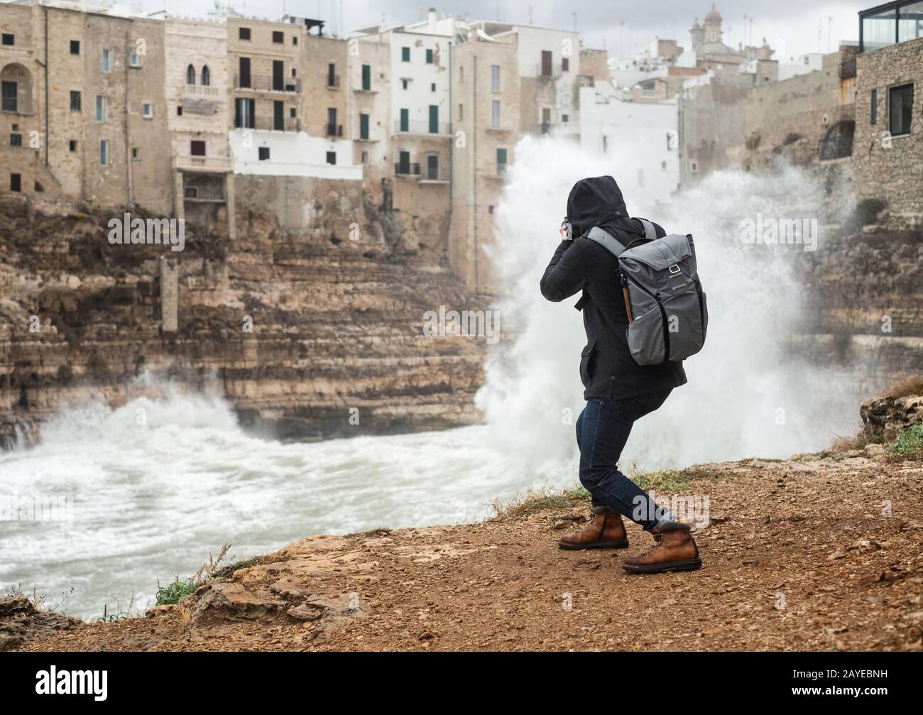 Photographe prenant photo d'une mer de tempête à Polignano a Mare, Italie. Banque D'Images