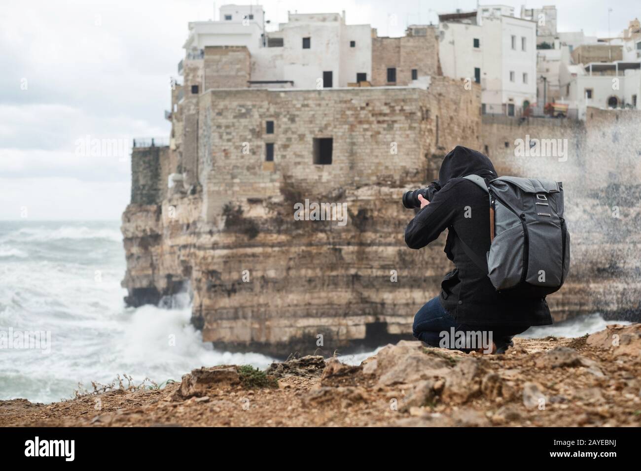 Photographe prenant photo d'une mer de tempête à Polignano a Mare, Italie. Banque D'Images