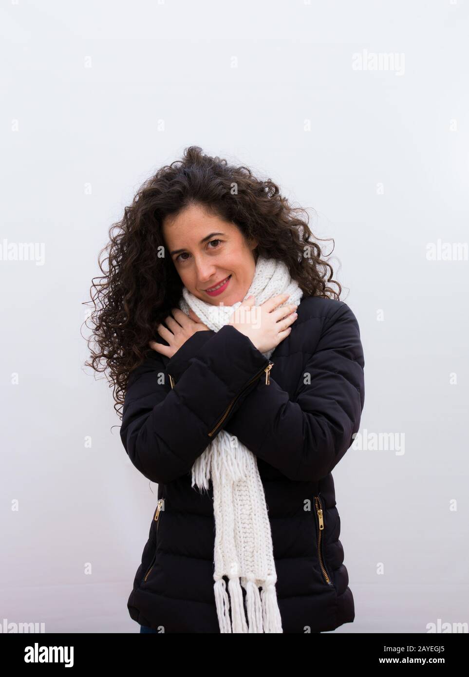 jeune jolie femme se sentant amoureux, souriante, couddling et embrassant soi, rester seule, être égoïste et égocentrique contre le mur blanc Banque D'Images