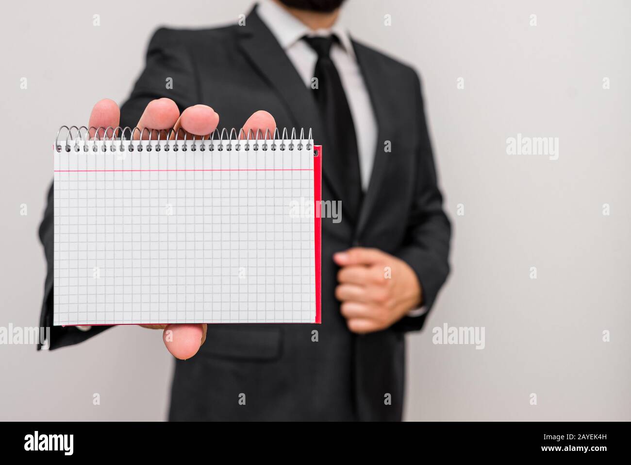 Homme debout et porter des vêtements de travail formels tenir des feuilles de maths papier. Homme vêtu d'une robe de costume de travail et d'un bureau à nouer Banque D'Images