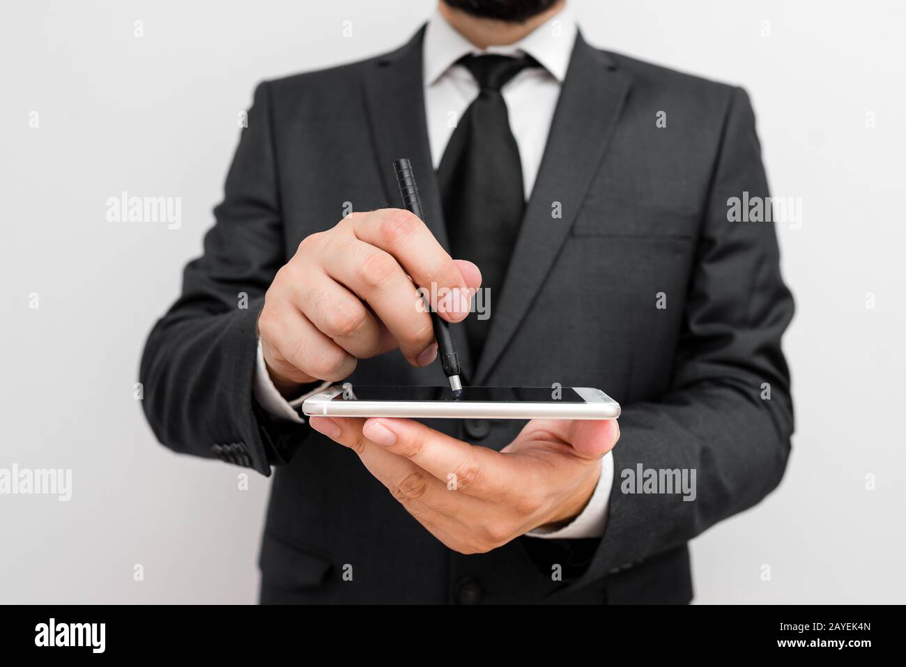 Homme avec barbe porter des vêtements de travail formels tenir l'appareil de smartphone haute technologie. Homme vêtu d'un costume de travail et d'une tenue de cravate Banque D'Images