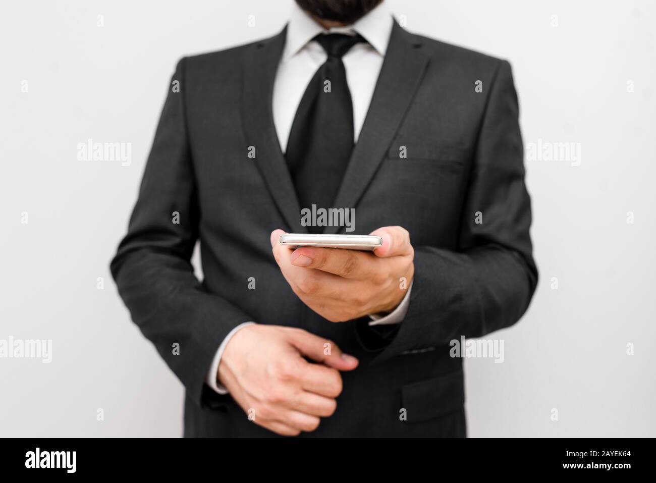 Homme avec barbe porter des vêtements de travail formels tenir l'appareil de smartphone haute technologie. Homme vêtu d'un costume de travail et d'une tenue de cravate Banque D'Images